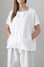 Blusa Prado blanca, vista frontal con silueta amplia y bolsillos delanteros