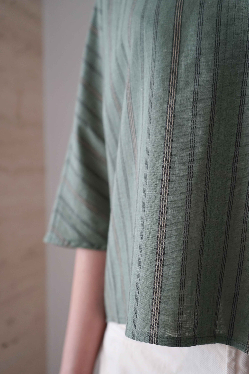Detail of the green striped fabric, sleeve and hem of the Marei blouse
