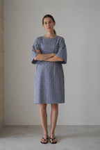 Amance dress in blue gingham, full-length front view with arms crossed
