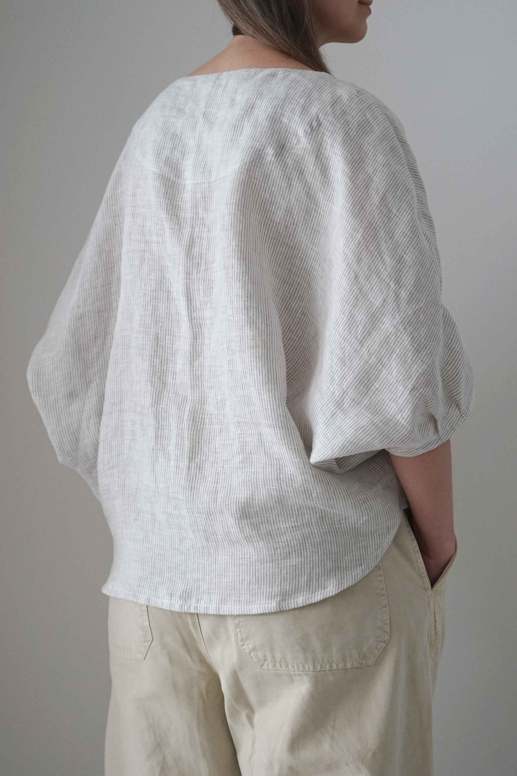 Blusa Emes a rayas grises, vista trasera en tres cuartos