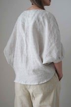 Blusa Emes a rayas grises, vista trasera en tres cuartos